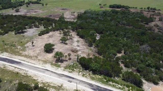 an aerial view of a house a yard and mountain