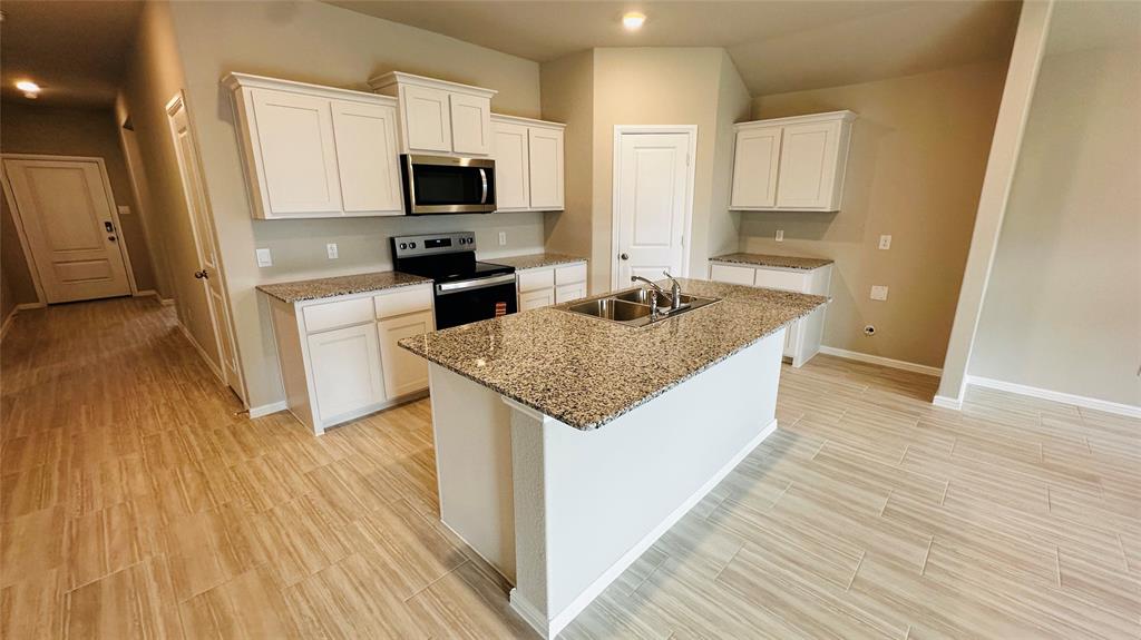 380 Wildrose Circle Cleburne, TX 76033 - Photo 19 of 20 a kitchen with granite countertop a sink and a stove top oven