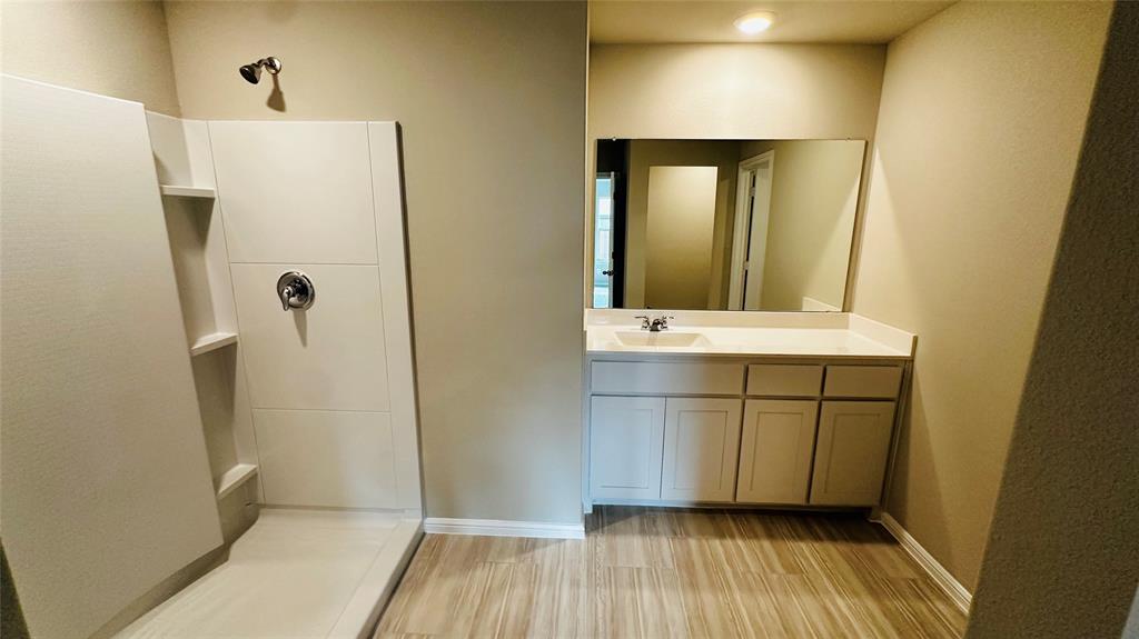 380 Wildrose Circle Cleburne, TX 76033 - Photo 8 of 20 a bathroom with a sink a mirror and a shower