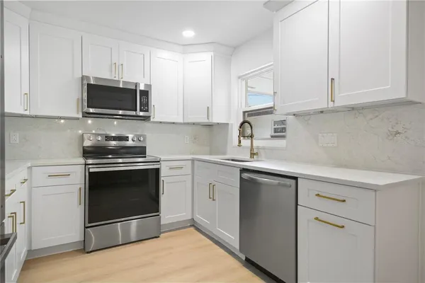 a close view of a sink and dishwasher in kitchen with stainless steel appliances