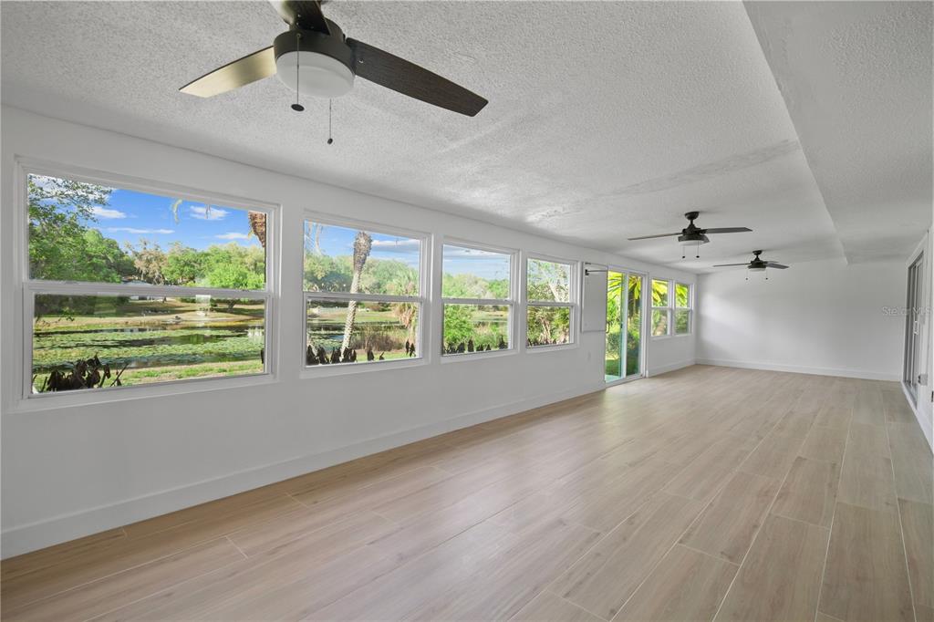 1501 Druid Isle Road Maitland, FL 32751 - Photo 31 of 54 an empty room with wooden floor fan and windows