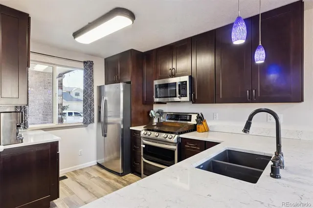 a kitchen with granite countertop a refrigerator and a stove top oven