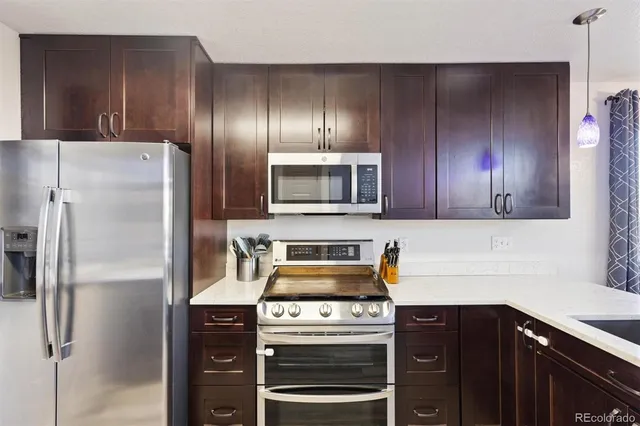 a kitchen with granite countertop stainless steel appliances and wooden cabinets