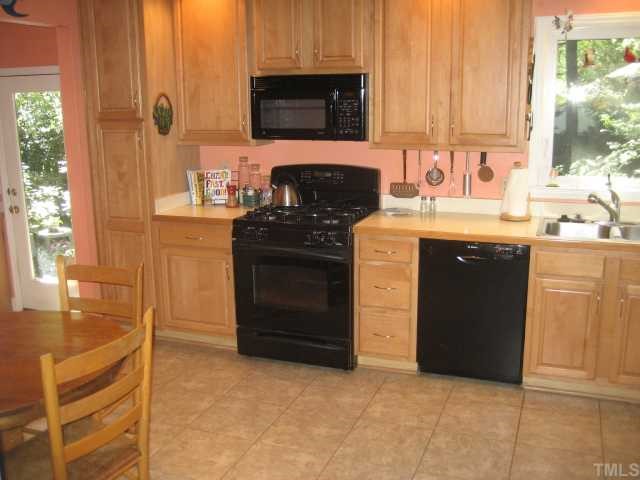 1545 Shadowood Lane Raleigh, NC 27612 - Photo 8 of 12 a kitchen with stainless steel appliances granite countertop a stove a sink and a microwave