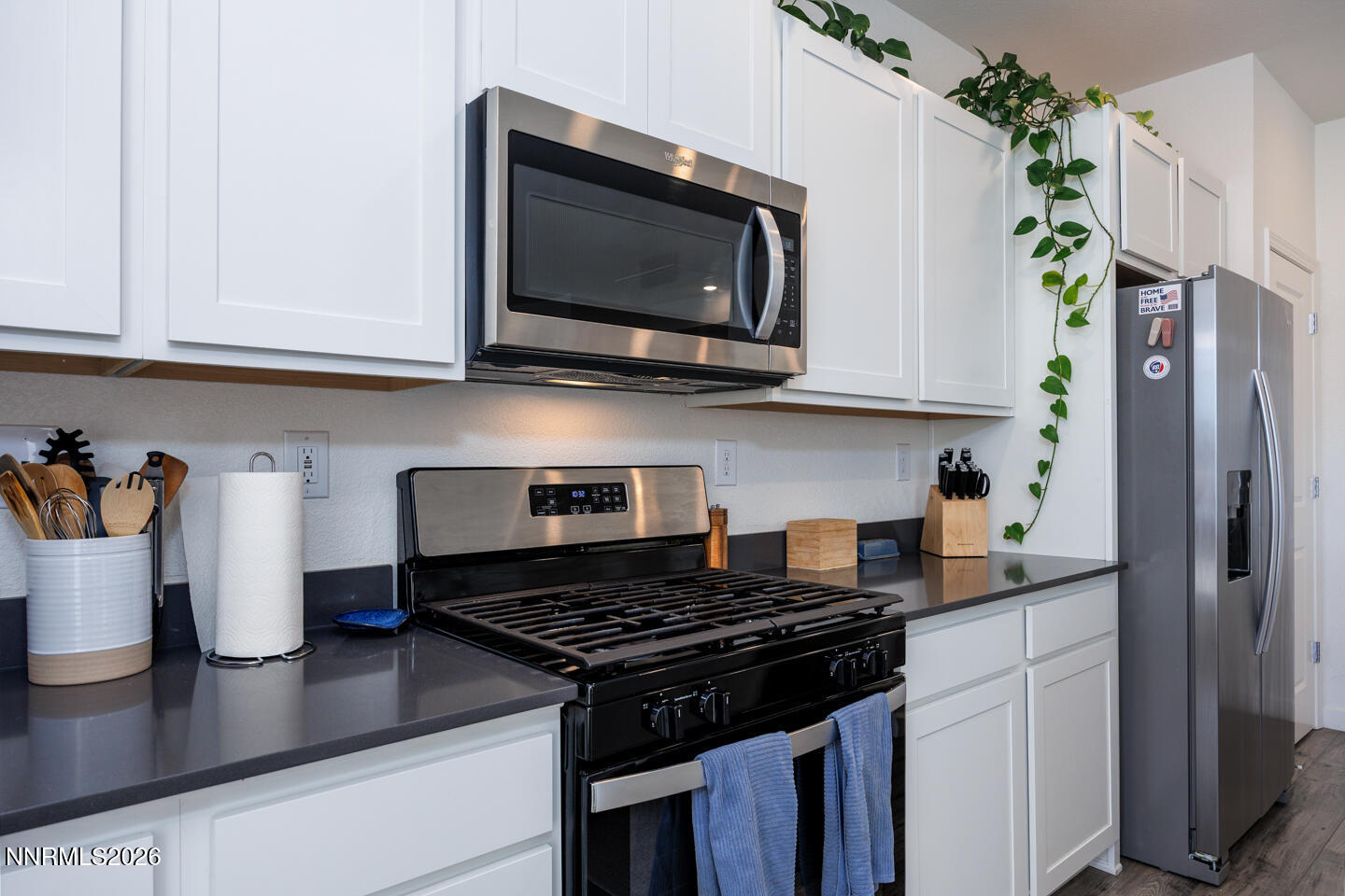 1049 Tamarack Court Fallon, NV 89406 - Photo 8 of 27 a kitchen with stainless steel appliances a stove a microwave a sink and cabinets