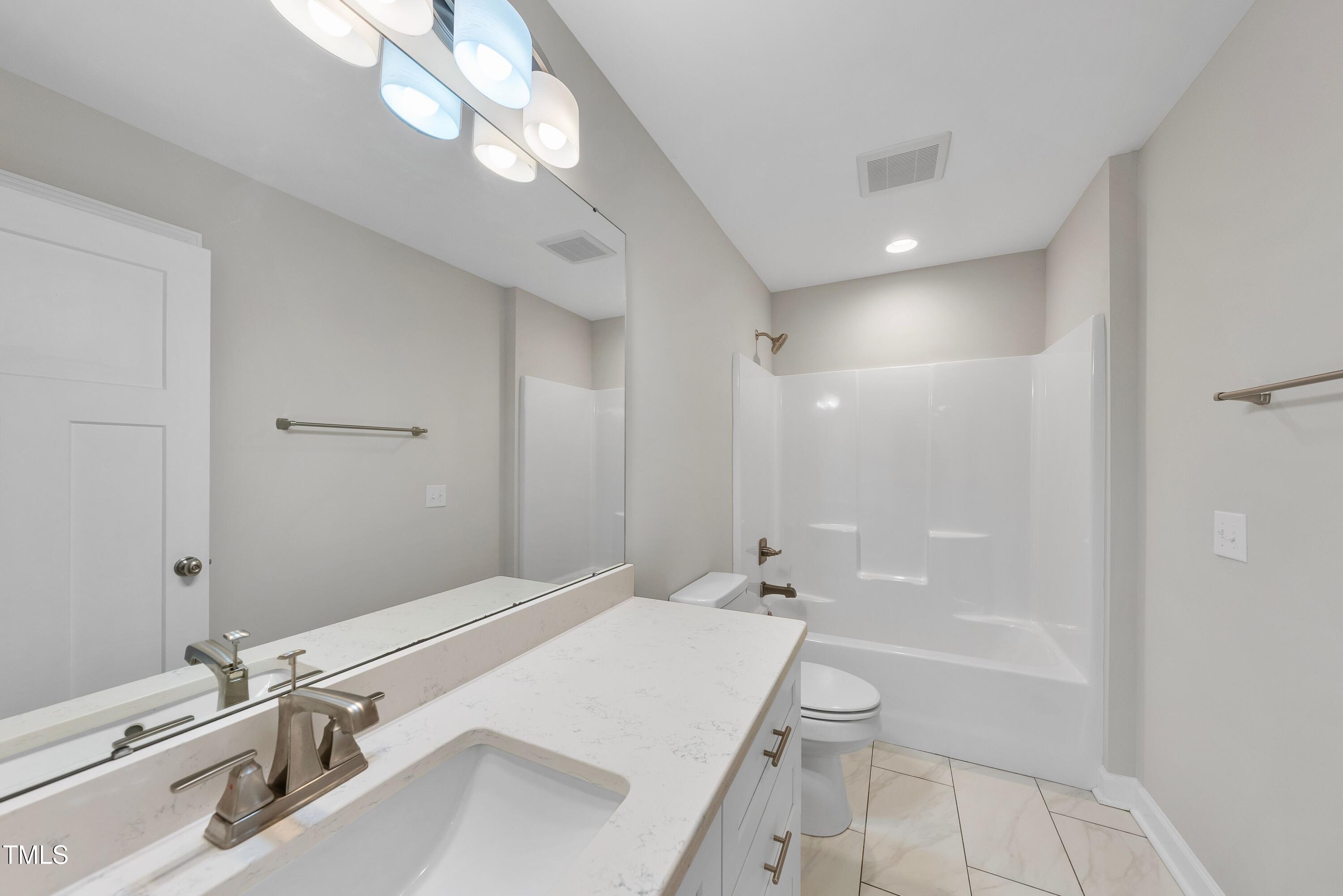 9425 Meredith Drive Rougemont, NC 27572 - Photo 21 of 29 a bathroom with a granite countertop sink a toilet and shower