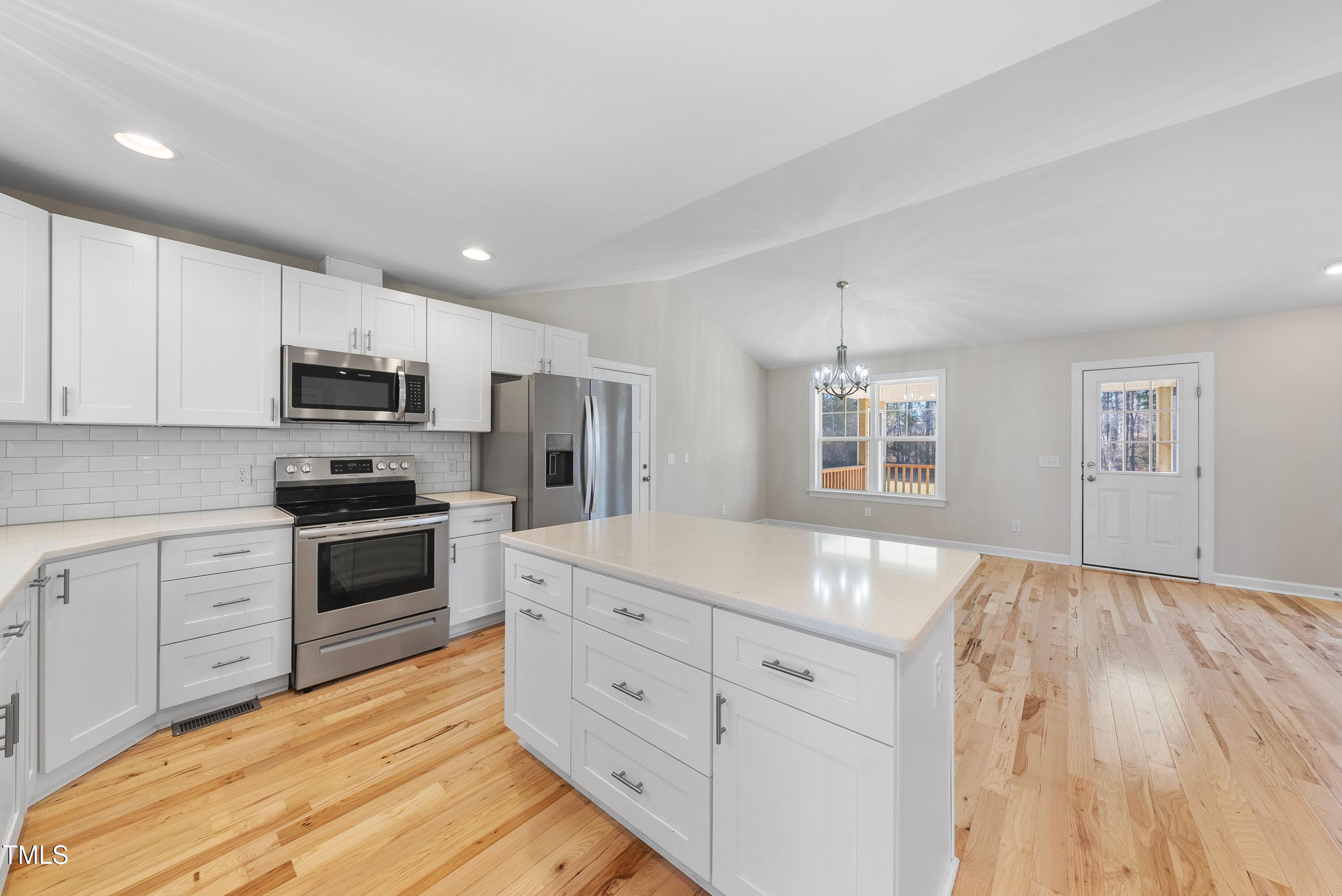 9425 Meredith Drive Rougemont, NC 27572 - Photo 4 of 29 a kitchen with granite countertop a stove top oven a sink dishwasher and a refrigerator with wooden floor