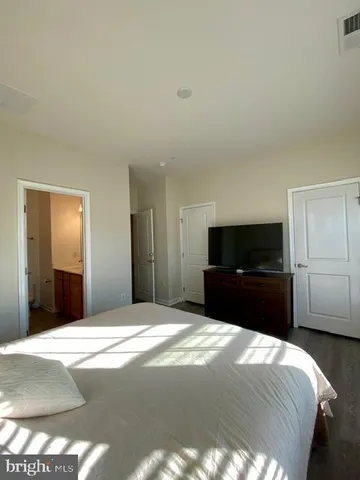 a bedroom with a bed and painting on the wall