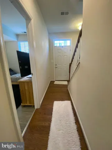 a view of a hallway with wooden floor and stairs