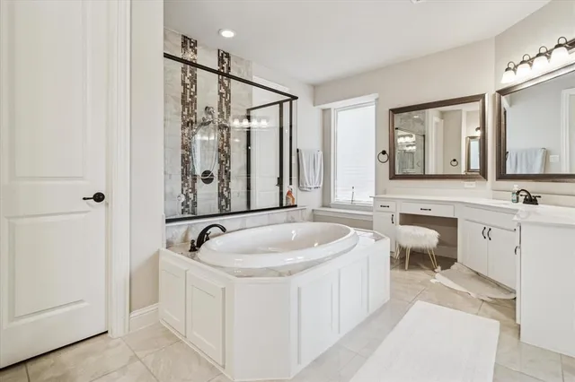 a spacious bathroom with bathtub a double vanity sink and mirror