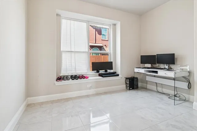 a view of a workspace with furniture and a window