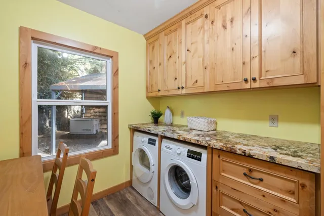 a utility room with granite countertop cabinets washer and dryer