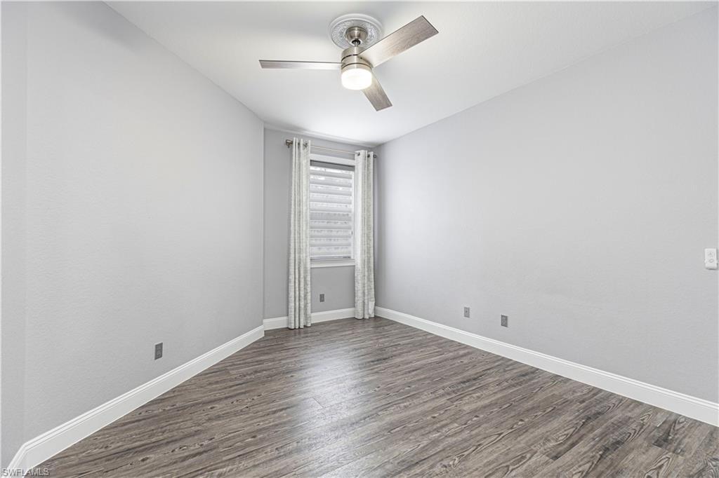 1330 Mariposa Circle, Unit 103 Naples, FL 34105 - Photo 19 of 32 wooden floor in an empty room