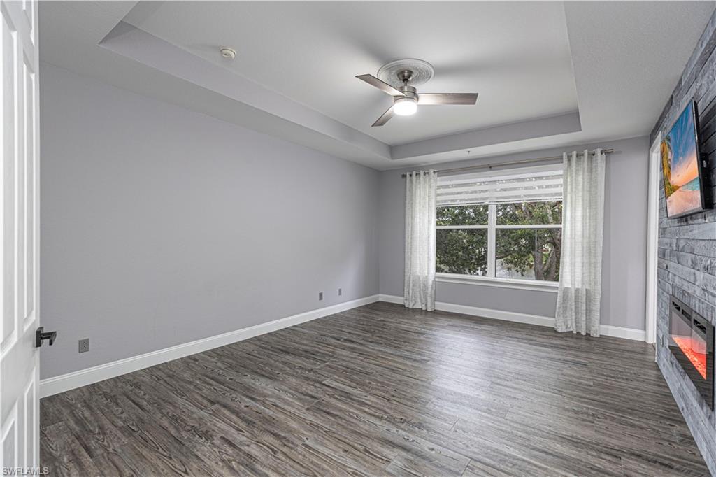 1330 Mariposa Circle, Unit 103 Naples, FL 34105 - Photo 22 of 32 a view of an empty room with wooden floor and a window