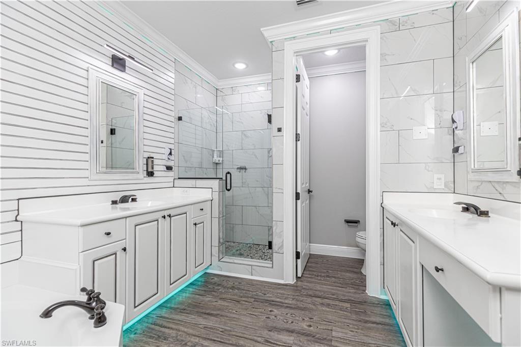 1330 Mariposa Circle, Unit 103 Naples, FL 34105 - Photo 25 of 32 a spacious bathroom with a double vanity sink a mirror and a shower