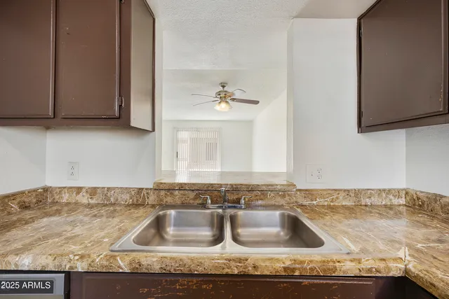 a bathroom with a granite countertop sink a mirror and cabinets