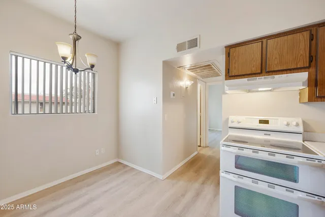 a kitchen with cabinets stainless steel appliances and wooden floor