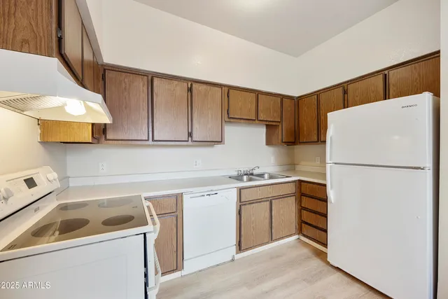 a view of an empty room with a chandelier fan