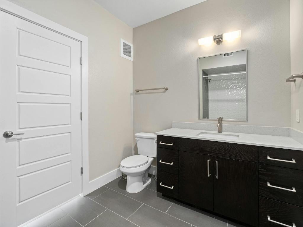 3114 South Congress Avenue, Unit 307 Austin, TX 78704 - Photo 15 of 19 a view of bathroom with a sink a toilet and mirror