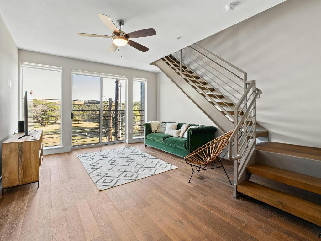 3114 South Congress Avenue, Unit 307 Austin, TX 78704 - Photo 3 of 19 a living room with wooden floor furniture and a ceiling fan