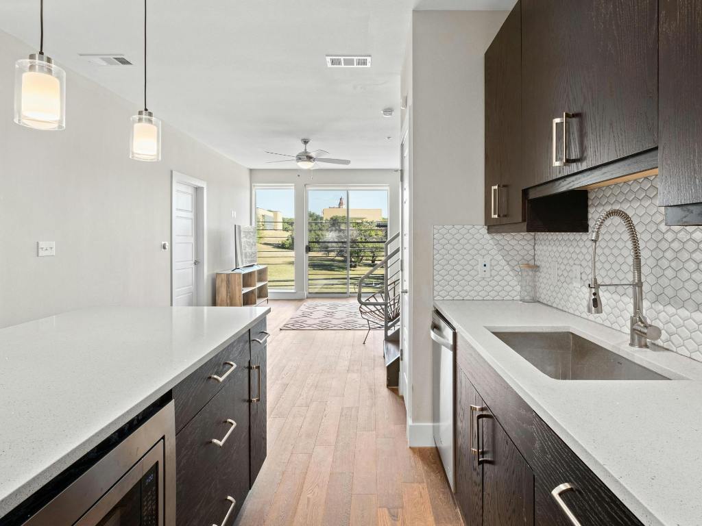 3114 South Congress Avenue, Unit 307 Austin, TX 78704 - Photo 6 of 19 a kitchen with a sink a stove and cabinets