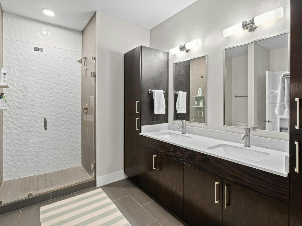 3114 South Congress Avenue, Unit 307 Austin, TX 78704 - Photo 10 of 19 a bathroom with a double vanity sink a large mirror and a shower