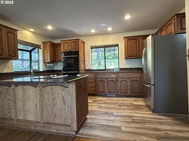 a kitchen with stainless steel appliances granite countertop a refrigerator and a sink