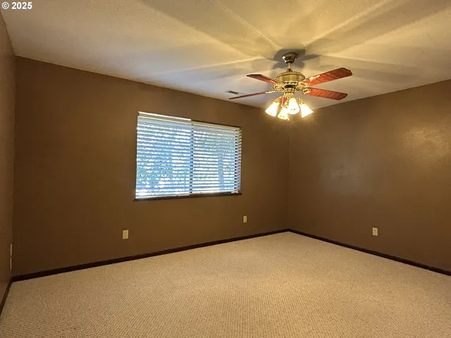 an empty room with closet and a chandelier fan