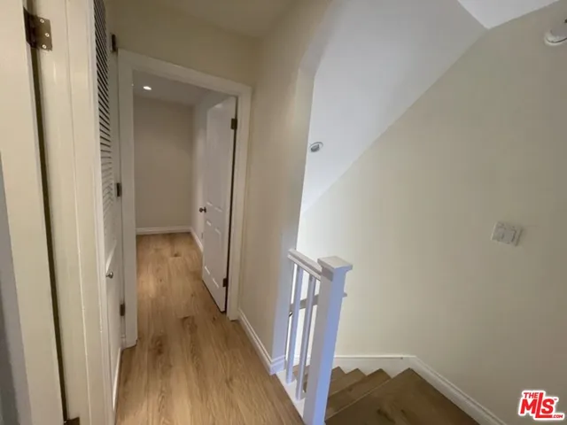 a view of a hallway with wooden floor and staircase