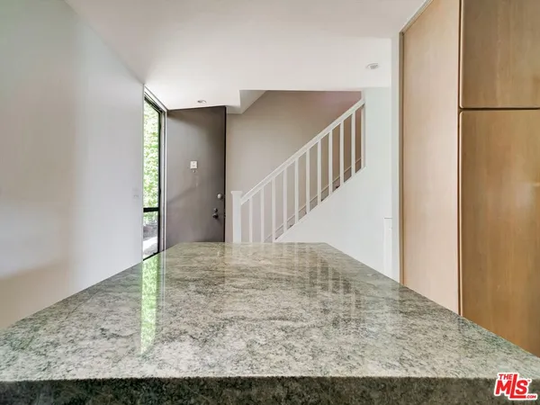 a kitchen with stainless steel appliances granite countertop a refrigerator a sink a stove and white cabinets