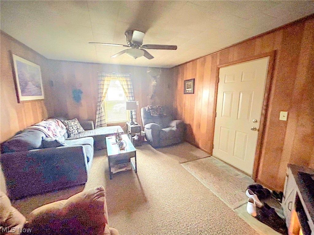 4726 Warren - Sharon Road Vienna, OH 44473 - Photo 3 of 15 Living room with wood walls, light colored carpet, and ceiling fan