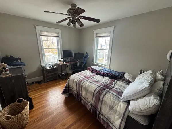 a bedroom with a bed and wooden floor