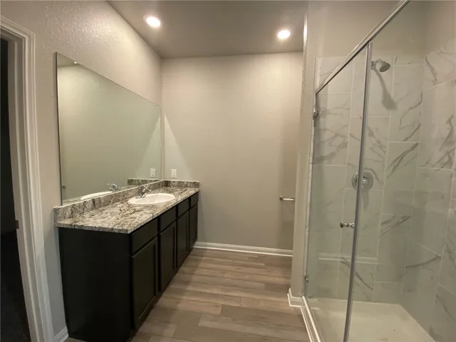 a bathroom with a granite countertop sink and mirror