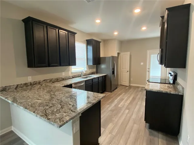 a kitchen with stainless steel appliances granite countertop a sink stove and refrigerator