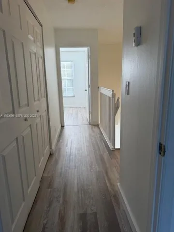 a view of a hallway with wooden floor