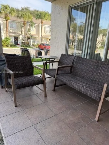 a living room with furniture and a floor to ceiling window