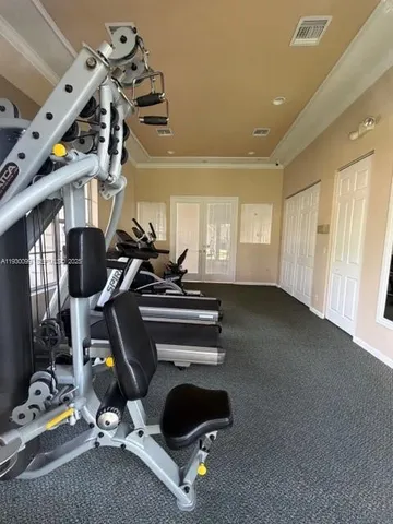 a room with gym equipment and wooden floor