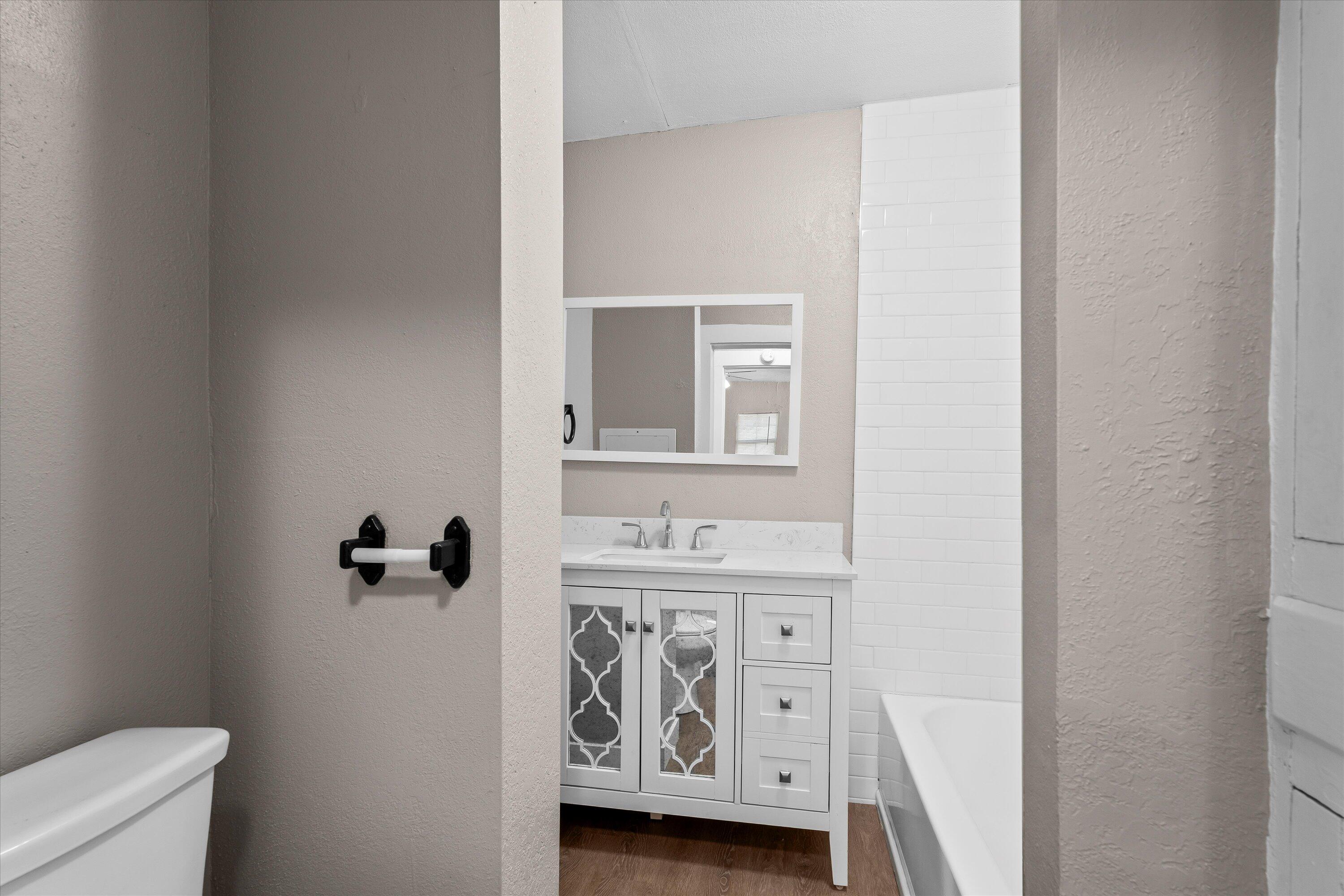 301 Austin Street Levelland, TX 79336 - Photo 13 of 18 a bathroom with a sink a toilet and a mirror