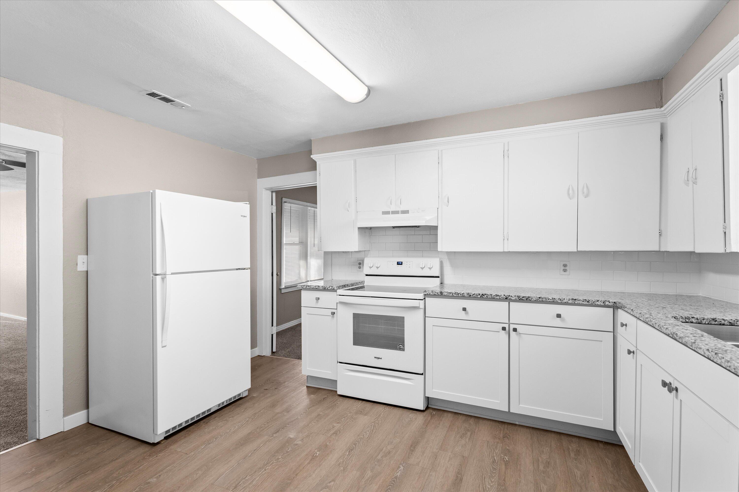 301 Austin Street Levelland, TX 79336 - Photo 7 of 18 a kitchen with a white cabinets and white appliances