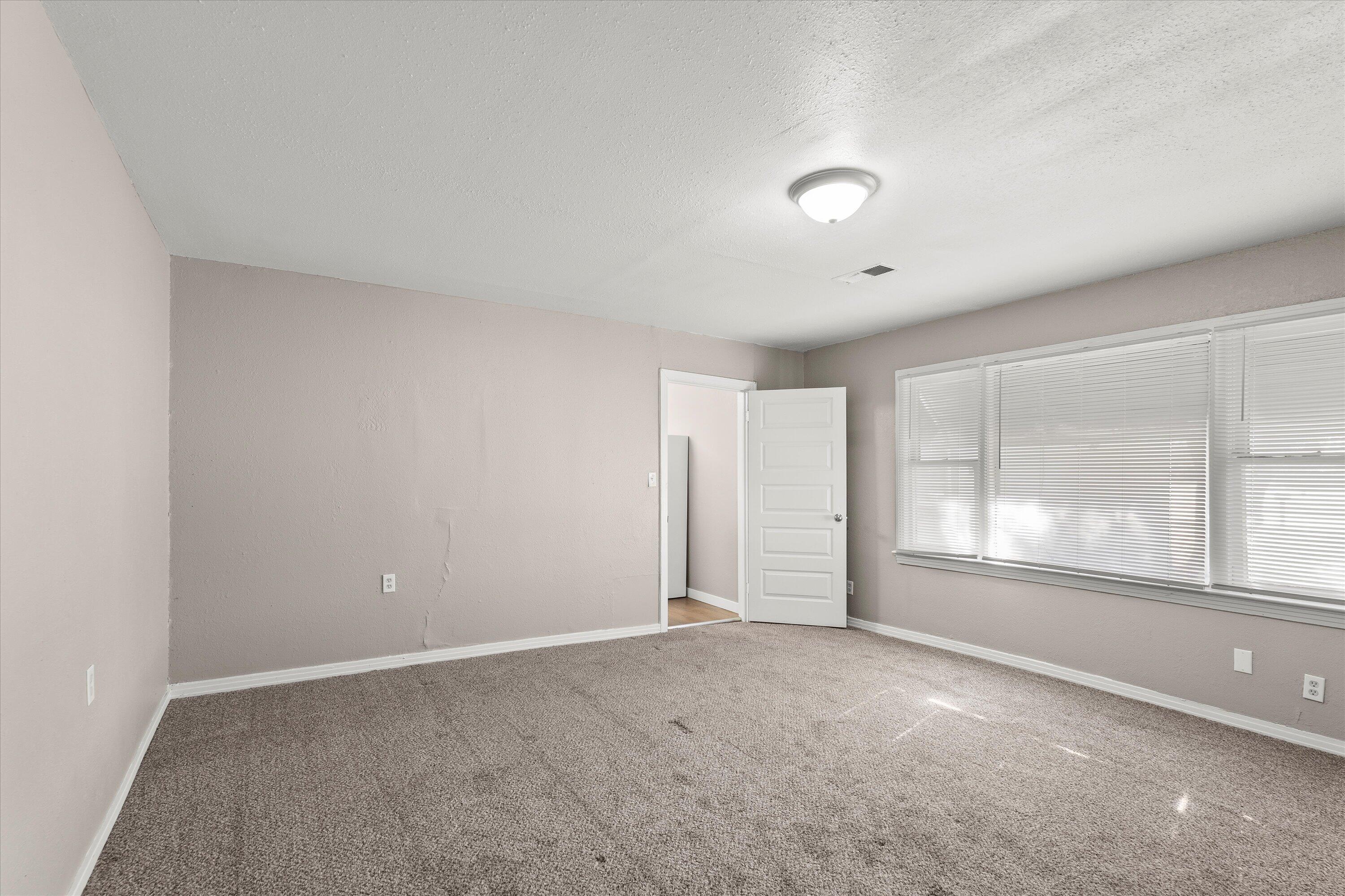 301 Austin Street Levelland, TX 79336 - Photo 9 of 18 an empty room with windows and view of an empty room