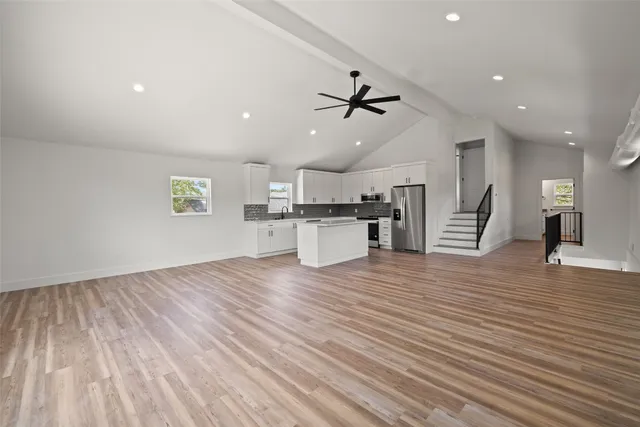 a kitchen with granite countertop a sink stove and refrigerator
