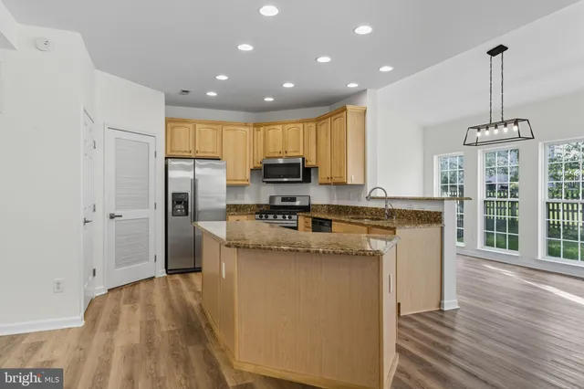 a kitchen with stainless steel appliances granite countertop a stove and a refrigerator
