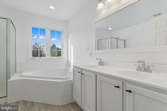 a bathroom with a tub a sink and mirror