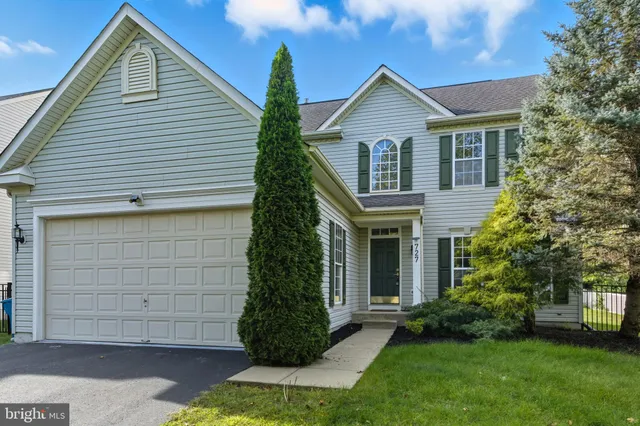 a view of house with a yard and potted plants