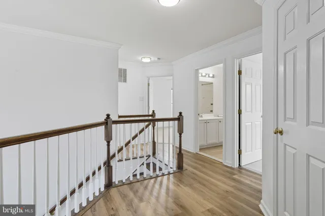 a view of a hallway with wooden floor and staircase