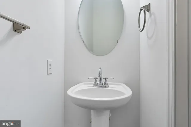 a bathroom with a sink a light fixture and a mirror