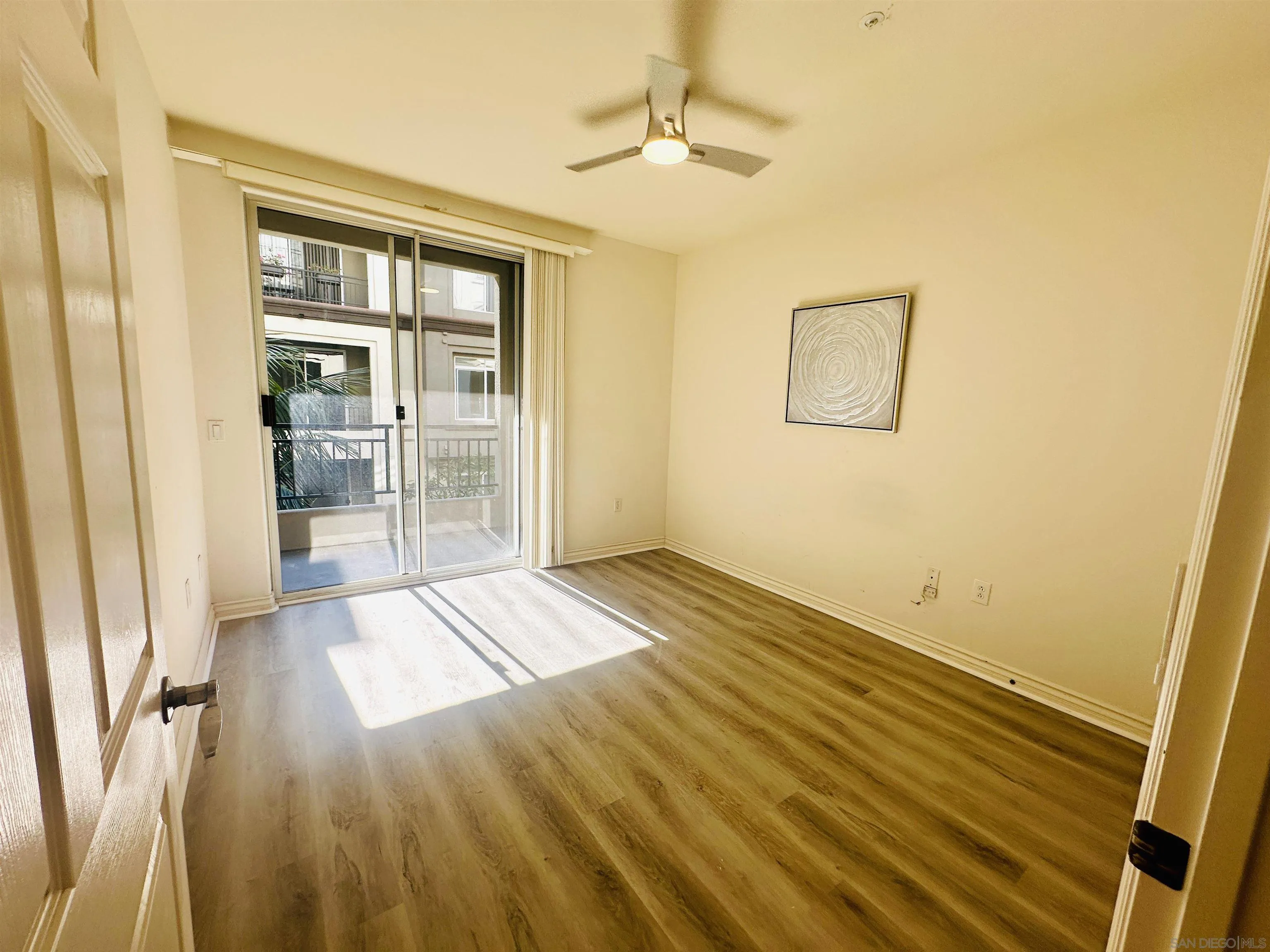 9263 Regents Road, Unit B204 La Jolla, CA 92037 - Photo 8 of 17 a view of an empty room with wooden floor and a window