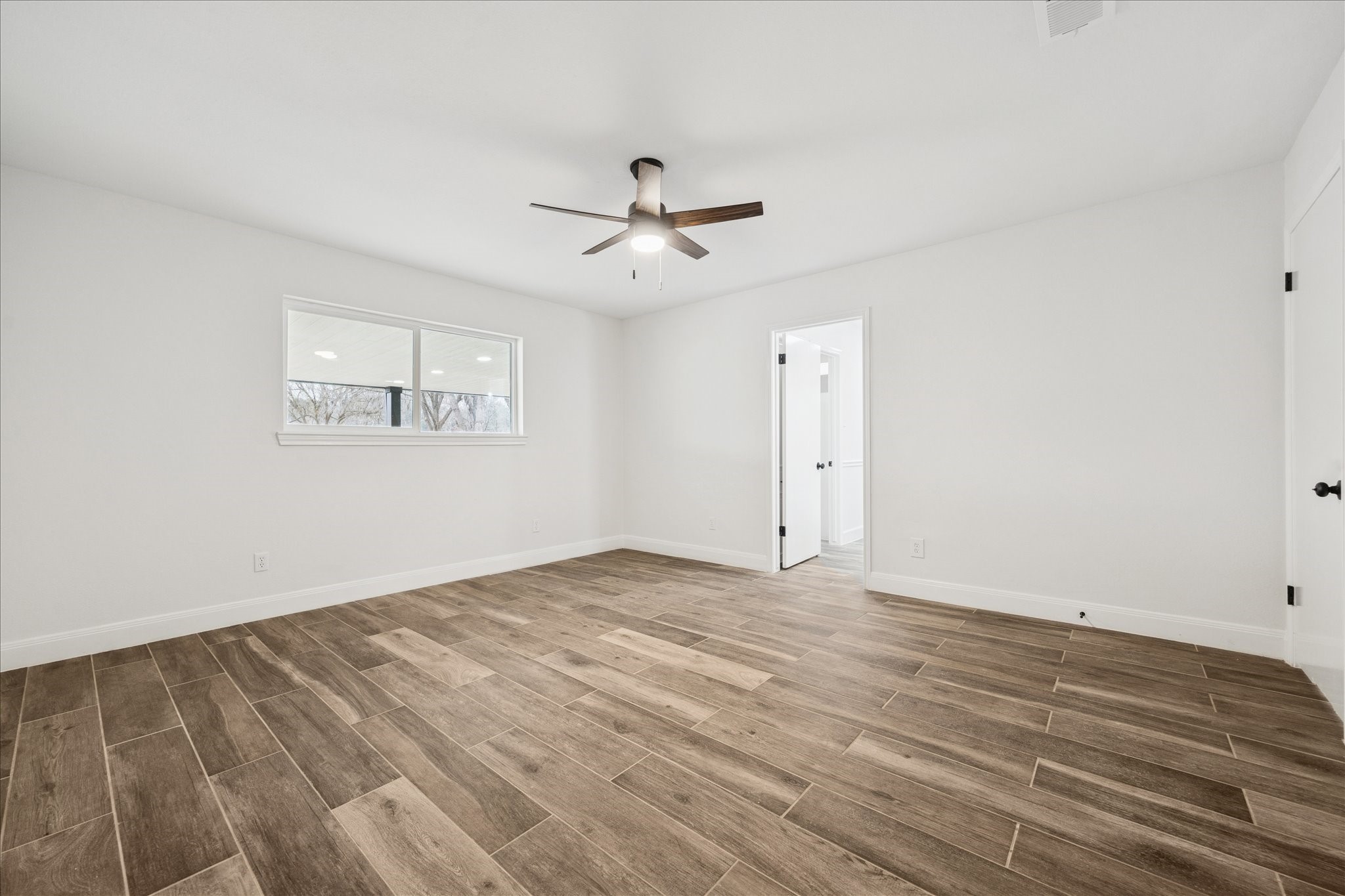 6911 Oak Lane Richmond, TX 77406 - Photo 25 of 42 an empty room with wooden floor ceiling fan and windows