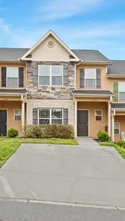 a front view of a house with a yard and a garage