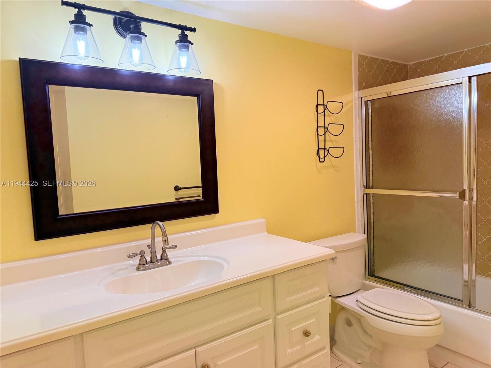 8951 North New River Canal Road, Unit 2D Plantation, FL 33324 - Photo 14 of 30 a bathroom with a sink vanity mirror and toilet